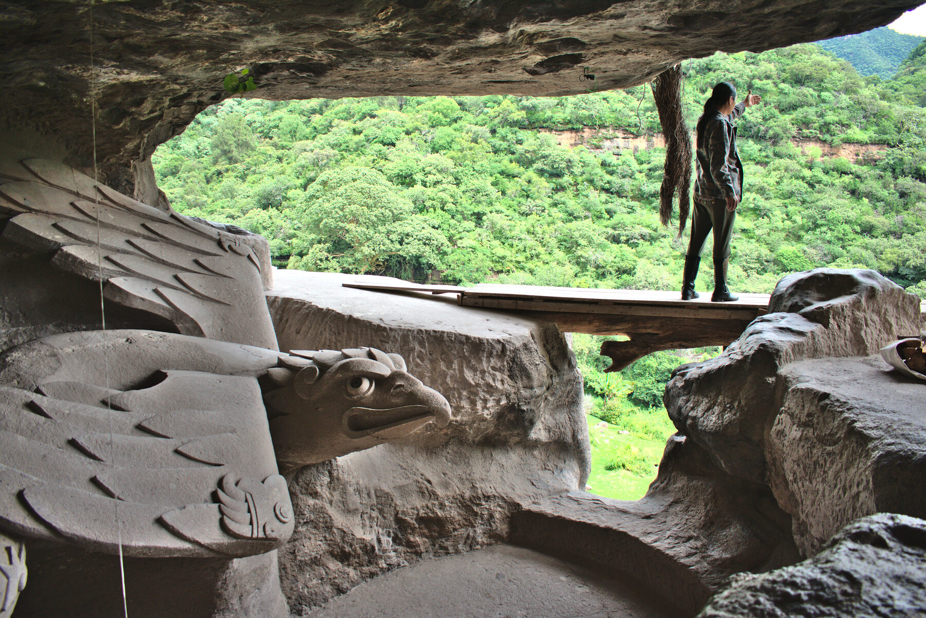 Interior del Cuauhcalli, con águilas talladas en la piedra y el valle al fondo